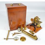 A cased unnamed brass and lacquered travelling monocular microscope with various accessories and a