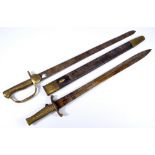 A late 19th century brass gripped bayonet with push button action and leather scabbard and a