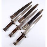 Three wooden handled and steel mounted bayonets, each with broad arrow and War Department stamps,