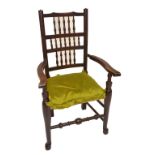 A 19th century country made spindle back elbow chair with string seat and turned stretchers.