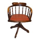 An early 20th century swivel spindle bar back office chair with padded seat.