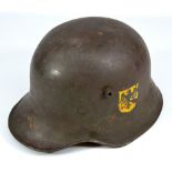 A German WWI helmet with applied black eagle decal to left side and interior leather lining and