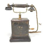 An early 20th century hand crank metal cased telephone with remains of painted decoration,