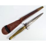 A Sykes Fairbairn type commando knife, with brass grip and shaped blade, in associated scabbard,
