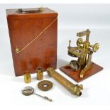 A cased brass monocular travelling microscope, with screw-off barrel, fitted with lens and eyepiece,