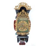 A late 19th century Dutch folklore clock with painted dial set with Roman numerals within repainted