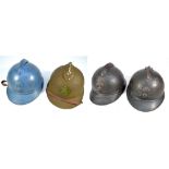 Four British Royal Fusiliers helmets, each with applied front badge and central ridge,