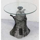 A revolving glass-top occasional table, the base formed from a Ford transmission block,
