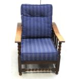 An early 20th century oak reclining armchair on barleytwist supports.