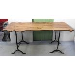 A pine trestle table, redesigned to resemble a section of a tree on black metal supports,