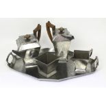 An Art Deco hammered polished pewter five-piece tea service with tray, marked for W A Perry & Co,