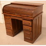 An early 20th century oak roll-top pedestal desk,