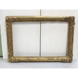 An ornate gilt frame, 136 x 95cm (af).