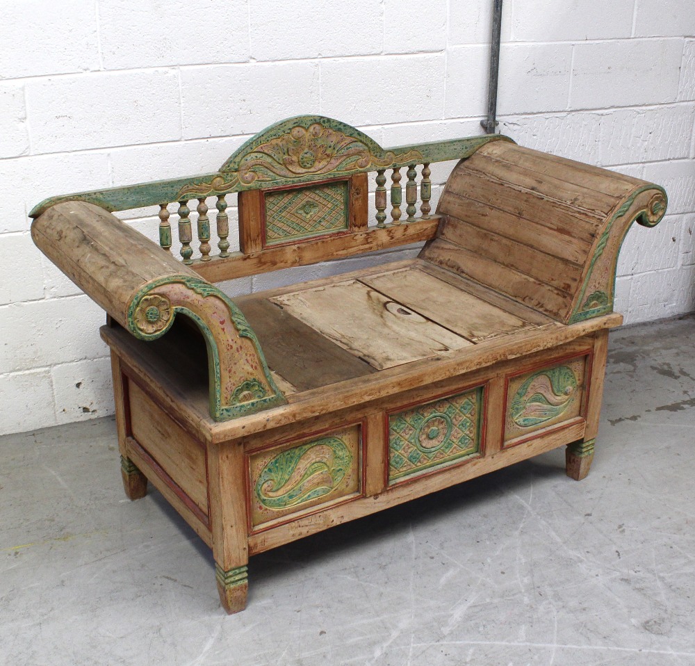 An Indian hardwood carved and panelled window seat with carved and turned back rail,