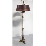 An early 20th century brass and maroon four-branch Regency-style standard lamp.