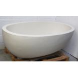 A Fired Earth ivory-coloured composite stone-effect oval bathtub, 174 x 100cm.