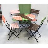A circular wooden garden table on metal stand and four matching slat garden chairs with metal