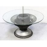 A revolving glass-top occasional table, the base formed from the engine of a Vulcan bomber,