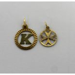 An 18ct gold pendant with letter 'K' in a circle and a 10ct gold pendant with a cross in a circle,