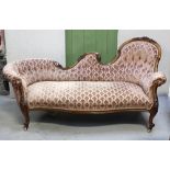 A Victorian walnut chaise longue, carved curving back to floral carved supports,