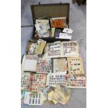 A vintage suitcase containing five stamp albums of world stamps and a further quantity of loose