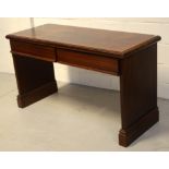 A contemporary mahogany desk with two front drawers, on slab supports, 137cm.