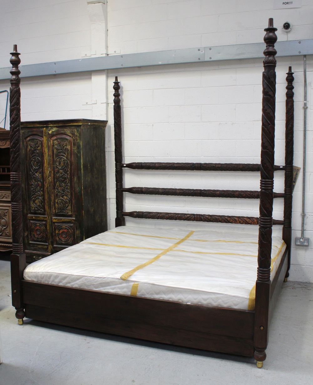 A 20th century Indian hardwood Colonial-style king size bed, three turned and carved back rails,