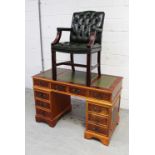 A reproduction yew wood pedestal desk and a buttoned green leather desk chair (2).