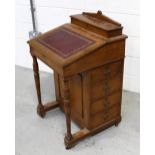 An Edwardian oak Davenport with lined hinged writing surface above four side drawers, width 54cm.