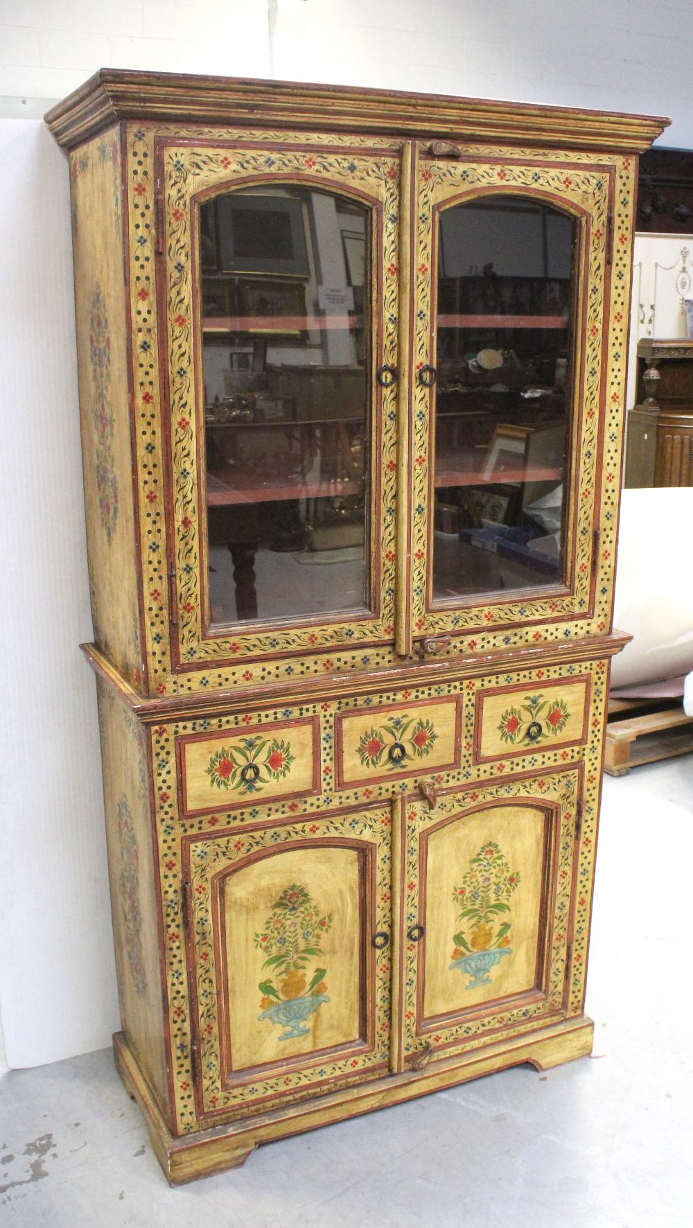 An Indian yellow-painted and waxed cabinet, hand-painted with floral decoration,