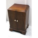 A c1940s mahogany music cabinet, two doors with ivory-effect decorated handles,