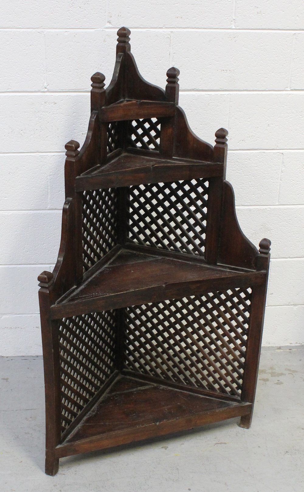 An Indian hardwood corner unit, four shelves with decorative lattice sides, 124 x 68cm.