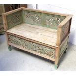 An Indian hardwood bench with carved and hand-painted panels to back and sides above a foliate