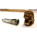 A white metal and mother of pearl cigar cutter and a netsuke of a Dog of Fo (2).