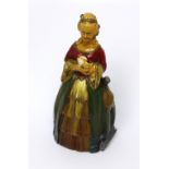 An early 20th century striker/lighter in the form of a young lady in period costume with a puppy,