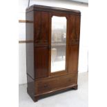 An Edwardian mahogany single-door wardrobe with Greek key carved decoration above a single drawer