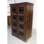 An Indian hardwood cabinet, two doors, each with four panels with metal lattice decoration,