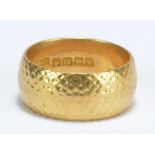 An 18ct yellow gold hammered wedding band, size V, approx 15g.