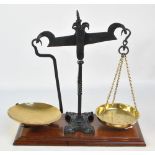 A pair of Edwardian wrought iron and brass bean scales on a mahogany base,