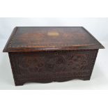 A late Victorian carved walnut rectangular chest with hinged lid centred with brass cartouche