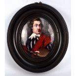 A 19th century oval portrait miniature depicting an artist with a paint palette wearing a red sash,