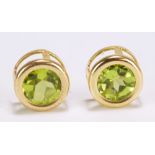 A pair of yellow metal and green peridot set ear studs.