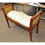 An Edwardian caned window seat with painted detail, width 102cm.