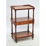 A Victorian walnut whatnot with central drawer, fluted turned uprights and turned feet to castors,