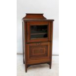 An Edwardian mahogany and inlaid music cabinet with glazed door enclosing two shelves above a