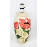 MOORCROFT; a 'Tulip' pattern tubeline decorated ovoid lamp base on cream ground,