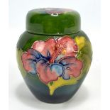 MOORCROFT; a 'Hibiscus' pattern tubeline decorated ginger jar and cover on blue ground,