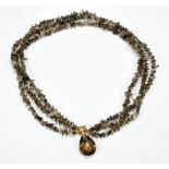 A three strand smoky quartz chip choker style necklace with unmarked yellow metal clasp,