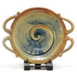 WALTER KEELER (born 1942); a salt glazed dish with four ornate handles, incised spiral to the well,