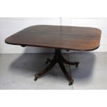 A 19th century mahogany tilt-top dining table on pedestal and quatrefoil support to castors,